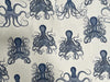 A close-up of a fabric or wallpaper pattern featuring navy blue octopus illustrations on a warm off-white background.